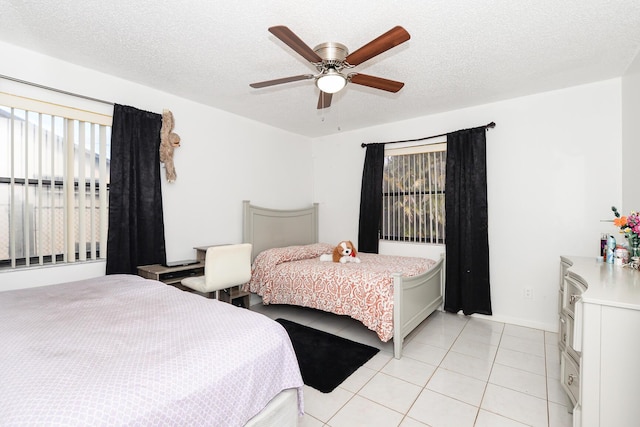 bedroom featuring light tile patterned floors, a textured ceiling, and a ceiling fan