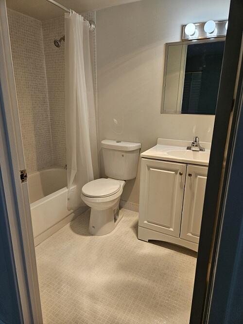 300 Village Green Cir S Unit 206, Palm Springs, FL 33461 - bathroom with shower / tub combo with curtain, tile patterned flooring, vanity, and toilet