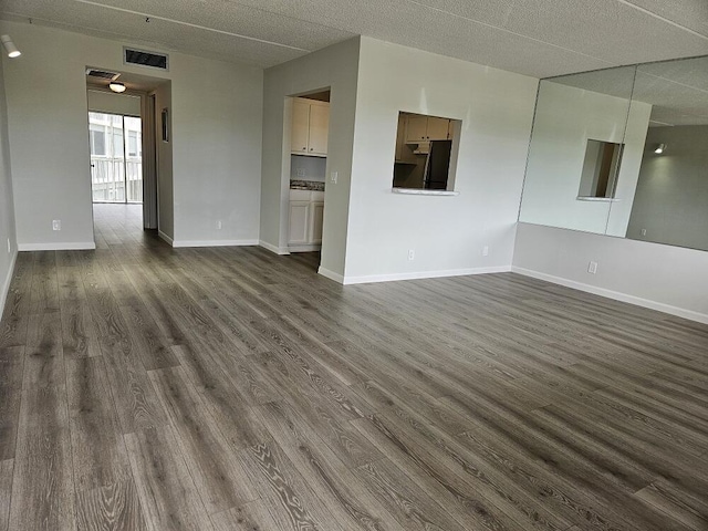 300 Village Green Cir S Unit 206, Palm Springs, FL 33461 - unfurnished living room with dark wood finished floors, visible vents, and baseboards