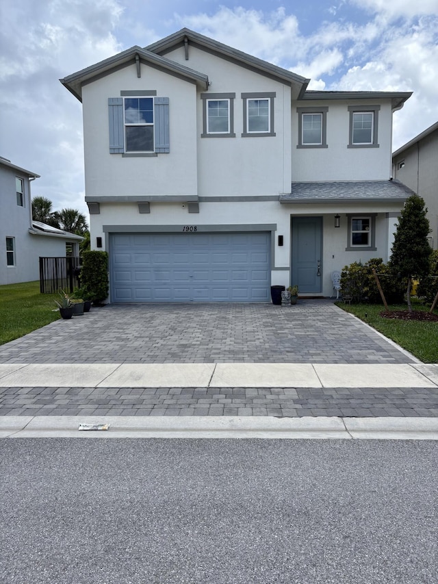 1908 Harding St, Lake Worth, FL 33460 - view of front facade featuring an attached garage, stucco siding, and decorative driveway