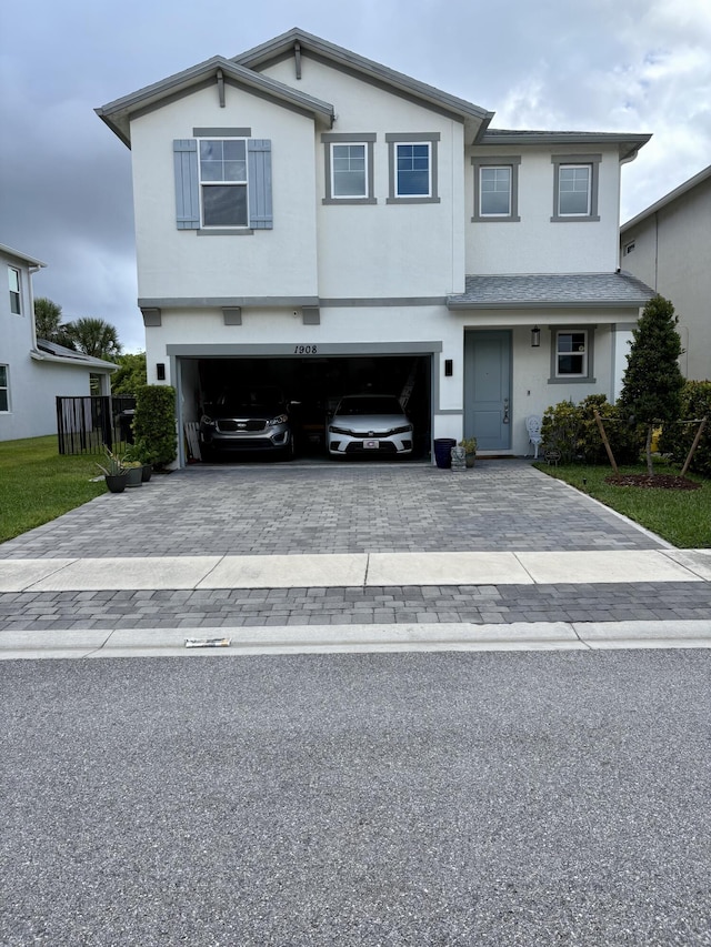 1908 Harding St, Lake Worth, FL 33460 - view of front of home featuring decorative driveway, a garage, and stucco siding