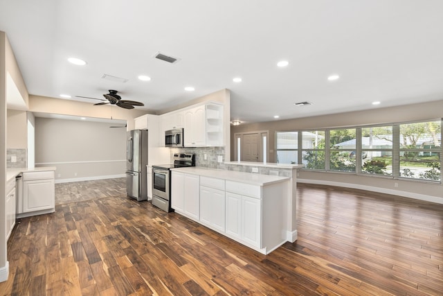 7 Riverview Dr, Sewalls Point, FL 34996 - kitchen featuring dark wood-style floors, white cabinetry, backsplash, visible vents, and appliances with stainless steel finishes