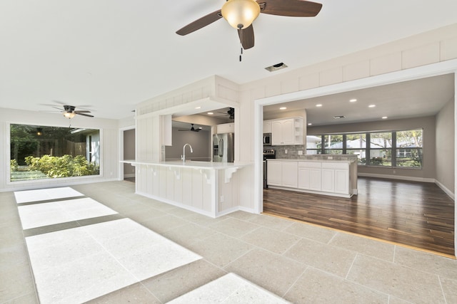 7 Riverview Dr, Sewalls Point, FL 34996 - interior space with open floor plan, ceiling fan, backsplash, and appliances with stainless steel finishes