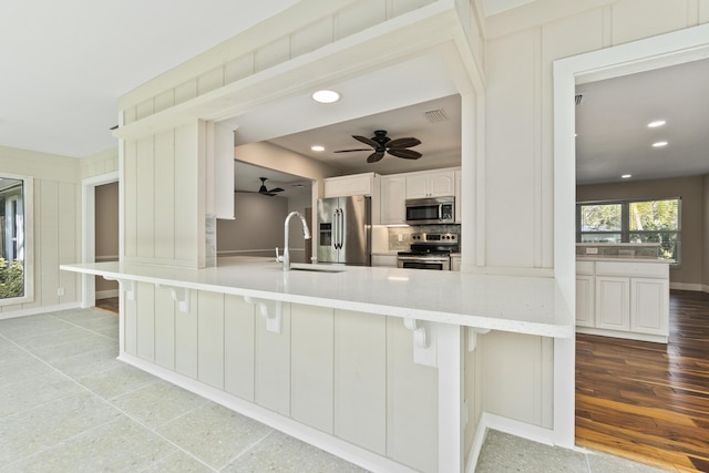 7 Riverview Dr, Sewalls Point, FL 34996 - kitchen featuring a breakfast bar area, visible vents, a sink, and appliances with stainless steel finishes