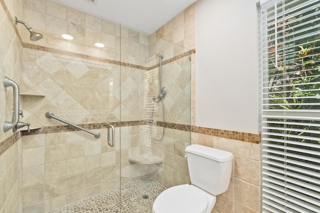 7 Riverview Dr, Sewalls Point, FL 34996 - bathroom featuring a shower stall, wainscoting, tile walls, and toilet