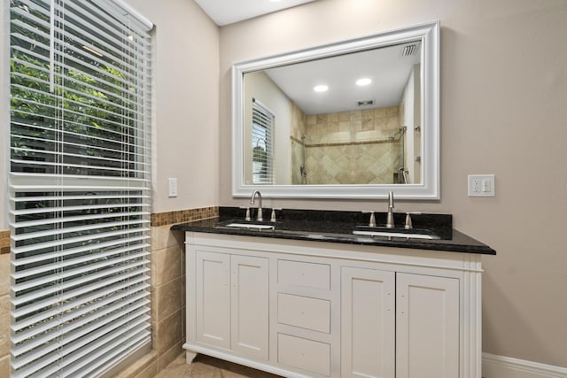 7 Riverview Dr, Sewalls Point, FL 34996 - full bathroom with double vanity, visible vents, a sink, and a stall shower