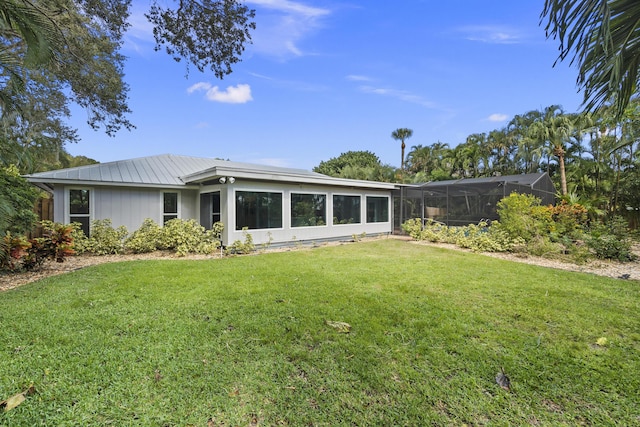 7 Riverview Dr, Sewalls Point, FL 34996 - rear view of house with glass enclosure and a lawn