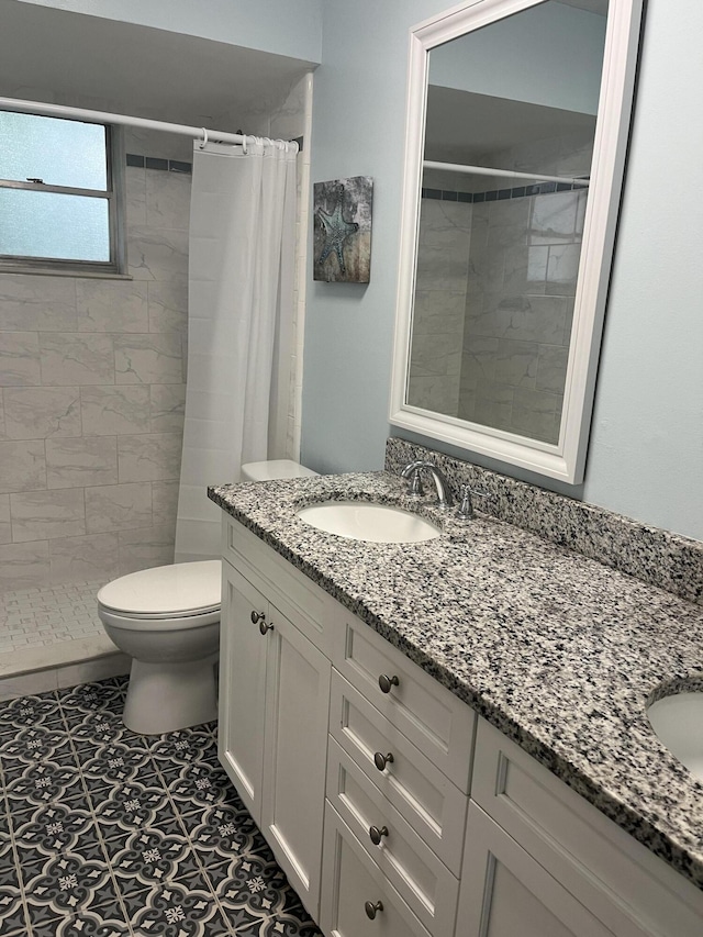 full bath featuring toilet, a tile shower, and vanity