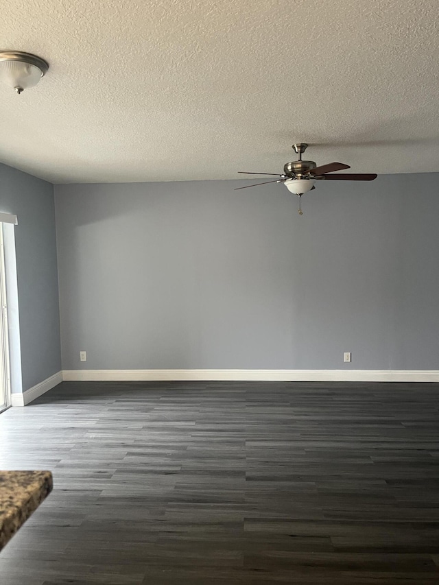 spare room featuring a textured ceiling, baseboards, a ceiling fan, and dark wood finished floors