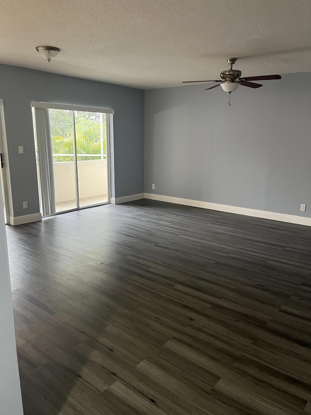 empty room featuring dark wood-style flooring, baseboards, a ceiling fan, and a textured ceiling