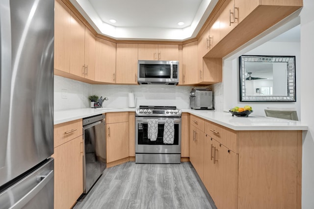 1013 Green Pine Blvd Unit A1, West Palm Beach, FL 33409 - kitchen featuring appliances with stainless steel finishes, light brown cabinets, a sink, light wood finished floors, and light countertops
