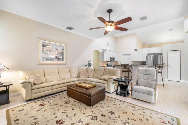 2020 Newhaven Ave, Wellington, FL 33414 - living room with light tile patterned floors, ceiling fan, baseboards, arched walkways, and vaulted ceiling