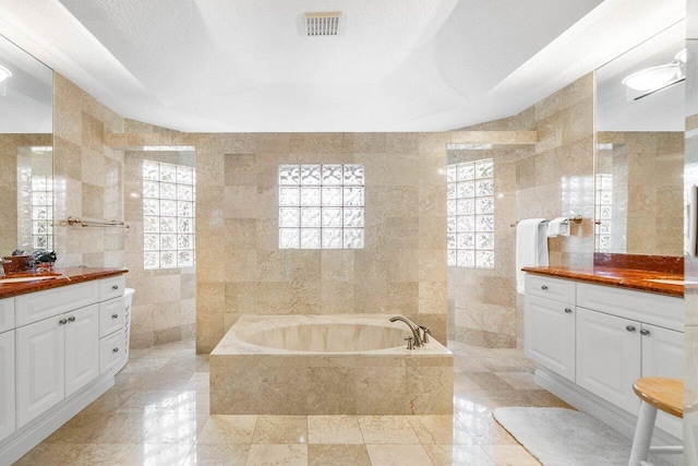 2020 Newhaven Ave, Wellington, FL 33414 - full bath featuring tile walls, vanity, a garden tub, plenty of natural light, and tile patterned floors