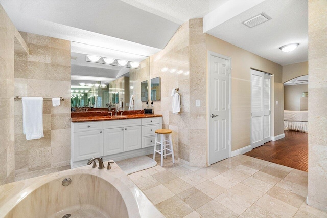 2020 Newhaven Ave, Wellington, FL 33414 - ensuite bathroom with tile walls, a garden tub, and vanity