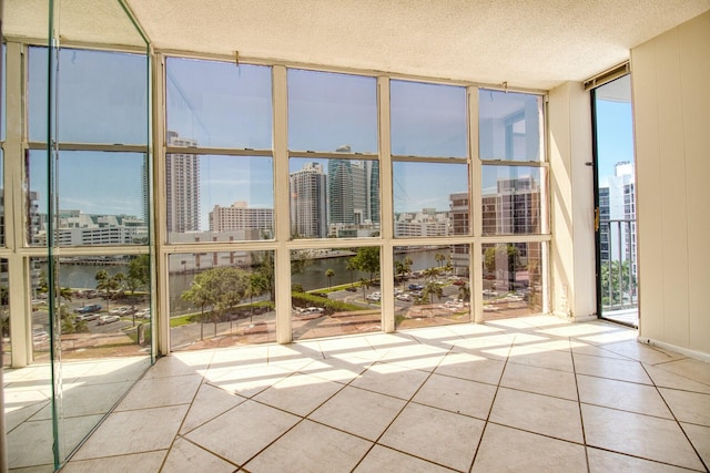 800 Parkview Dr Unit 826, Hallandale Beach, FL 33009 - unfurnished sunroom featuring floor to ceiling windows, a textured ceiling, tile patterned floors, a city view, and a water view