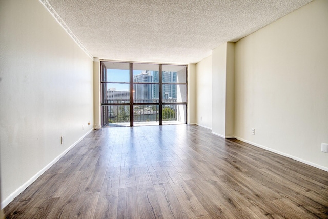 800 Parkview Dr Unit 826, Hallandale Beach, FL 33009 - empty room with a textured ceiling, floor to ceiling windows, dark wood-style floors, and baseboards