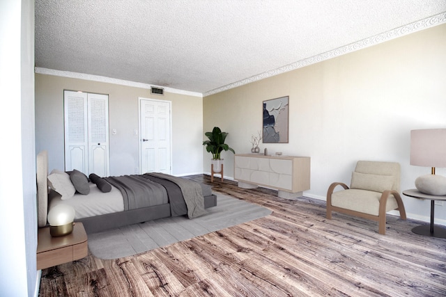 800 Parkview Dr Unit 826, Hallandale Beach, FL 33009 - bedroom featuring wood finished floors, ornamental molding, a textured ceiling, and visible vents