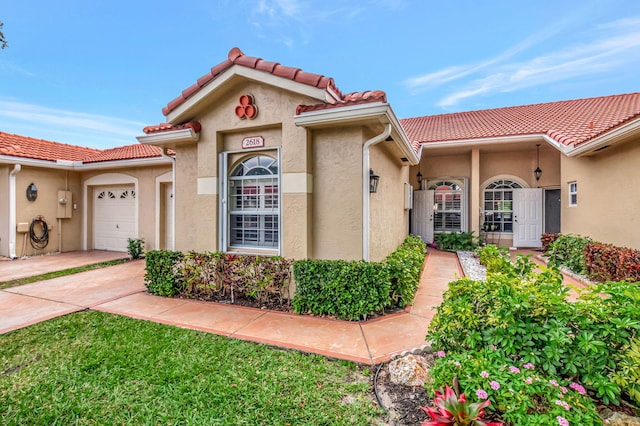 view of front of property with a garage, stucco siding, concrete driveway, and a tile roof
