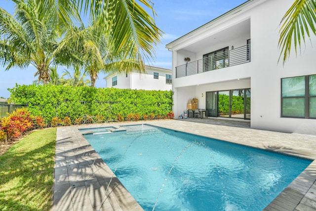 view of swimming pool with a patio area, a pool with connected hot tub, and a fenced backyard