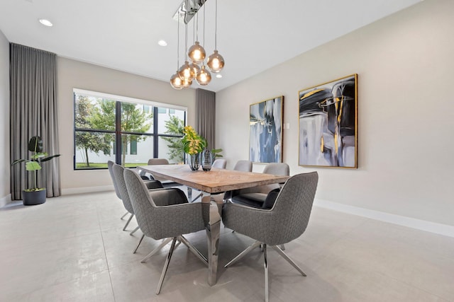 dining space featuring a notable chandelier, baseboards, and recessed lighting