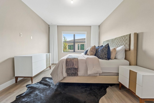 bedroom with baseboards and wood finished floors