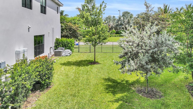 view of yard featuring central AC unit and fence