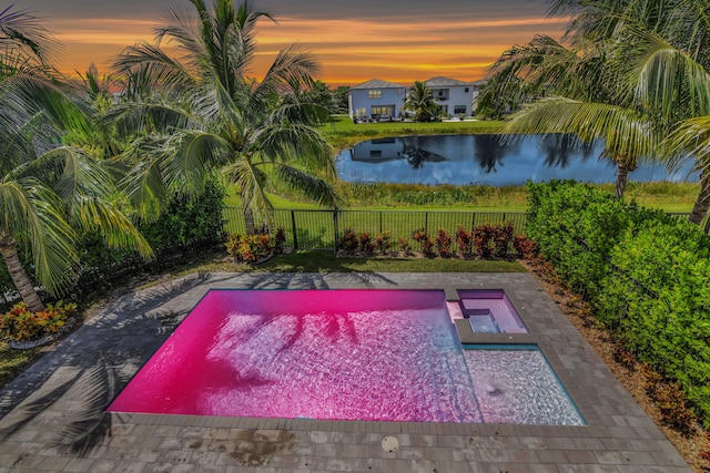 pool at dusk featuring a water view, a fenced in pool, and a fenced backyard