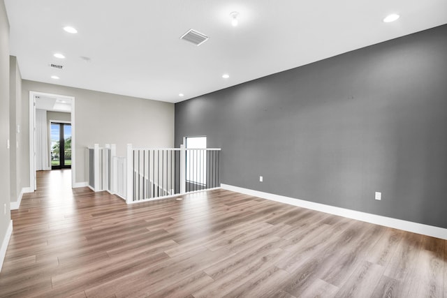 empty room featuring baseboards, visible vents, and light wood-style floors