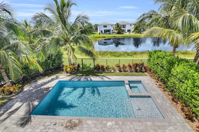 view of pool with a pool with connected hot tub, a water view, and a fenced backyard