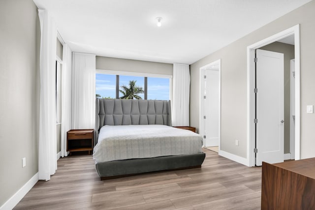 bedroom with light wood-style flooring and baseboards