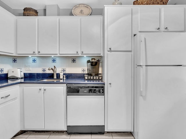kitchen featuring a sink, white appliances, white cabinets, and dark countertops