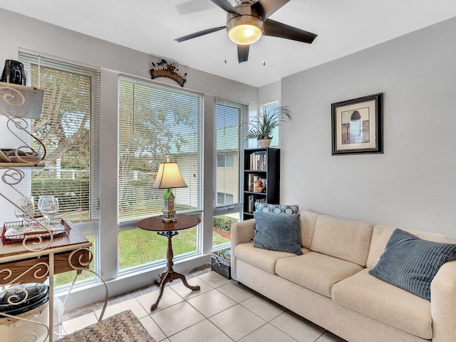 living area with light tile patterned floors and a ceiling fan