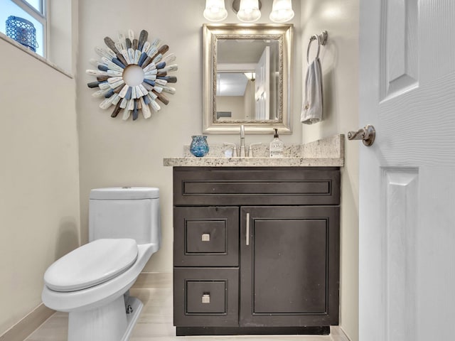 half bathroom featuring toilet, wood finished floors, vanity, and baseboards