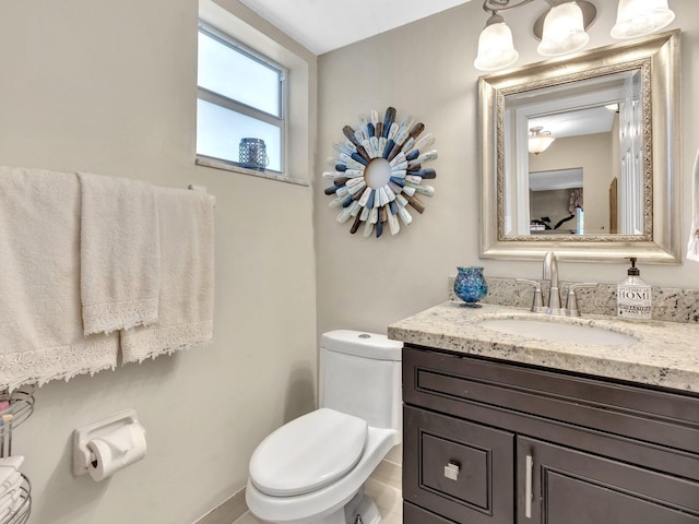 half bath featuring vanity and toilet