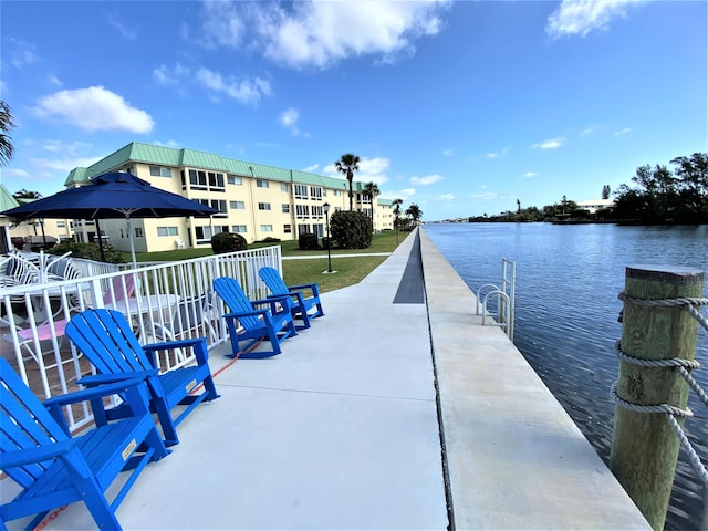 dock area with a water view and a yard