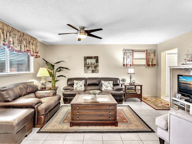 living area featuring a textured ceiling, light tile patterned floors, a ceiling fan, and a wealth of natural light
