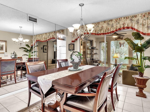 dining room featuring a textured ceiling, light tile patterned floors, a notable chandelier, and visible vents