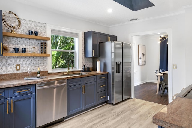 1021 N Palmway, Lake Worth Beach, FL 33460 - kitchen featuring appliances with stainless steel finishes, a sink, crown molding, blue cabinets, and light wood-type flooring