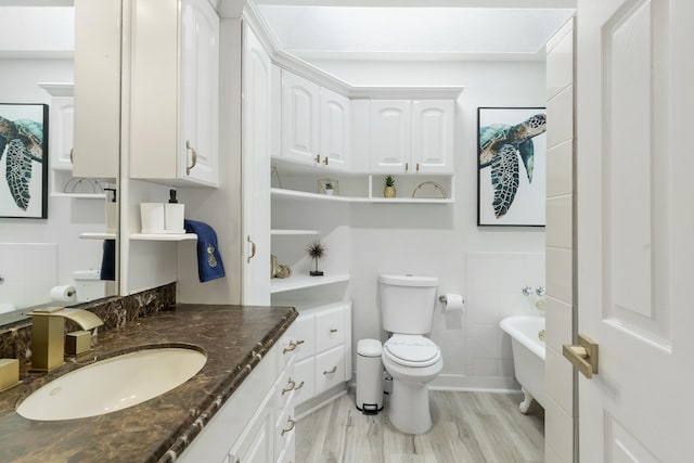 1021 N Palmway, Lake Worth Beach, FL 33460 - full bathroom featuring wood finished floors, a soaking tub, toilet, and vanity