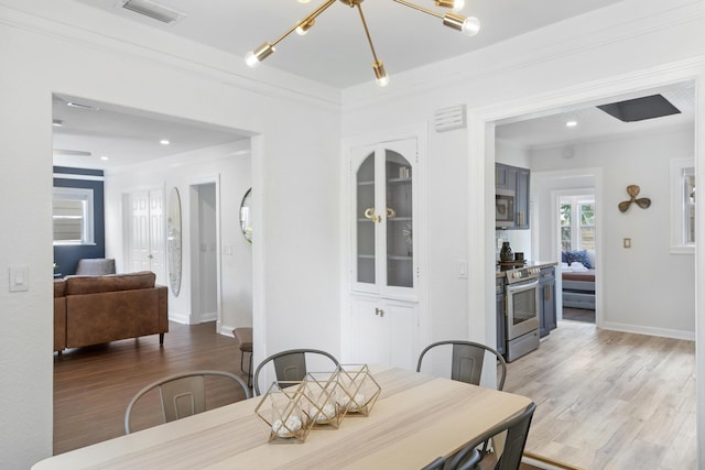 1021 N Palmway, Lake Worth Beach, FL 33460 - dining room with a chandelier, light wood-style flooring, crown molding, baseboards, and recessed lighting