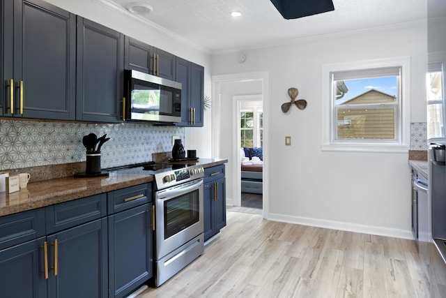 1021 N Palmway, Lake Worth Beach, FL 33460 - kitchen featuring appliances with stainless steel finishes, blue cabinetry, backsplash, light wood-style flooring, and ornamental molding
