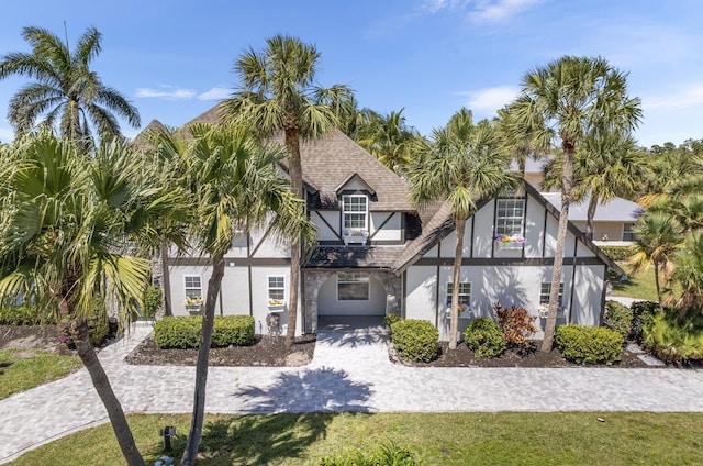 121 Queen Eugenia Ct, Hutchinson Island, FL 34949 - tudor house with stucco siding and a shingled roof