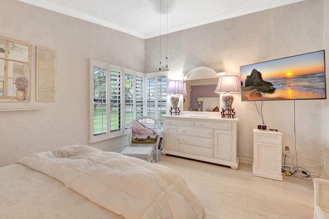 bedroom with a high ceiling, light wood-type flooring, and ornamental molding