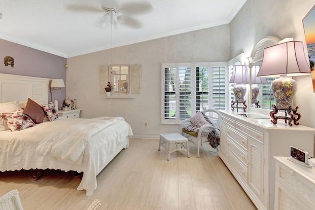 bedroom featuring a ceiling fan, light wood finished floors, ornamental molding, and vaulted ceiling