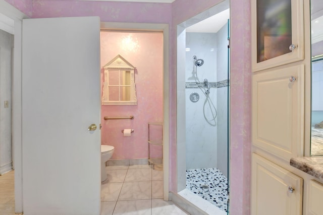 bathroom with vanity, baseboards, a stall shower, tile patterned floors, and toilet