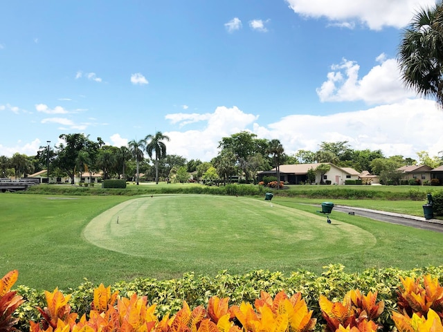 surrounding community featuring view of golf course and a lawn