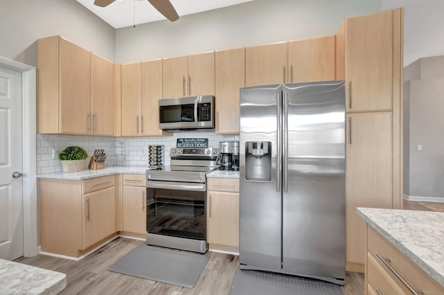 kitchen featuring tasteful backsplash, light wood-type flooring, light brown cabinets, and appliances with stainless steel finishes
