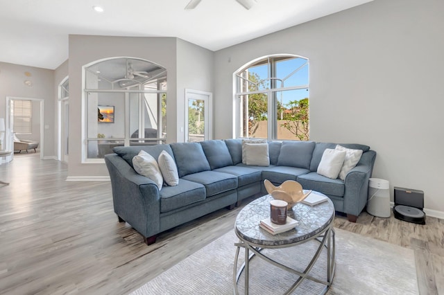 living room featuring light wood-style flooring, baseboards, a ceiling fan, and recessed lighting