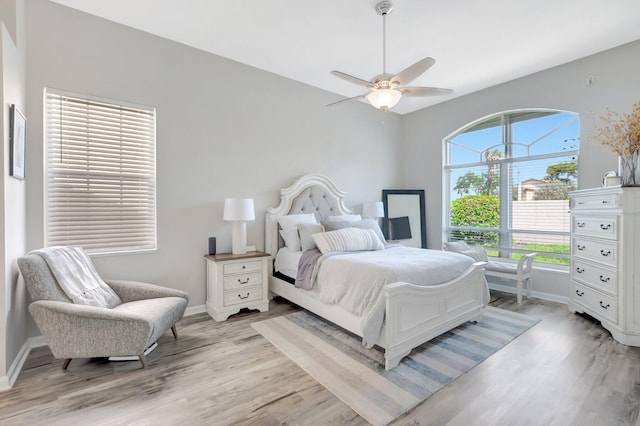 bedroom featuring light wood-style floors, baseboards, and a ceiling fan