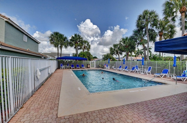 pool with a patio area and fence